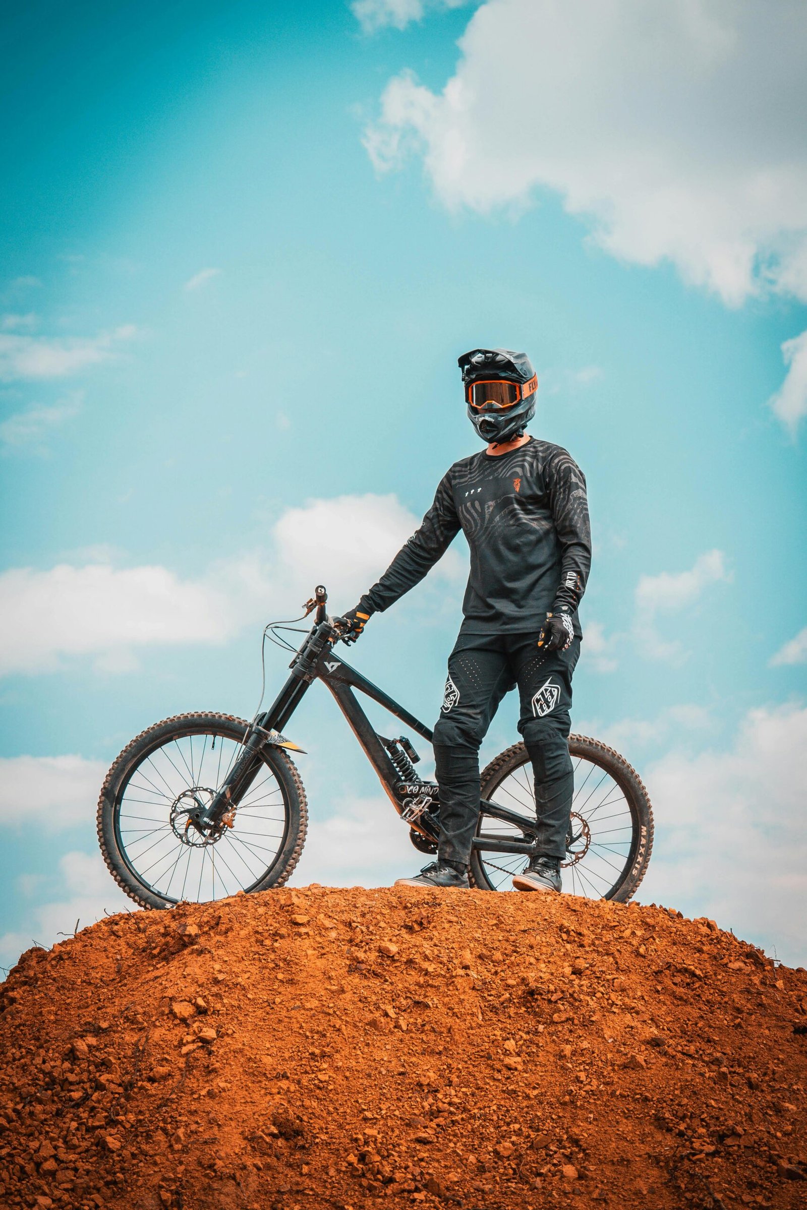 Mountain biker standing with bike on dirt hill, La Fragua, Mexico.